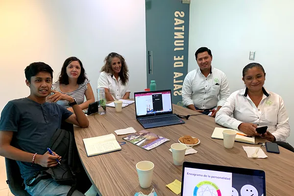 Participantes trabajando alrededor de una mesa durante el taller