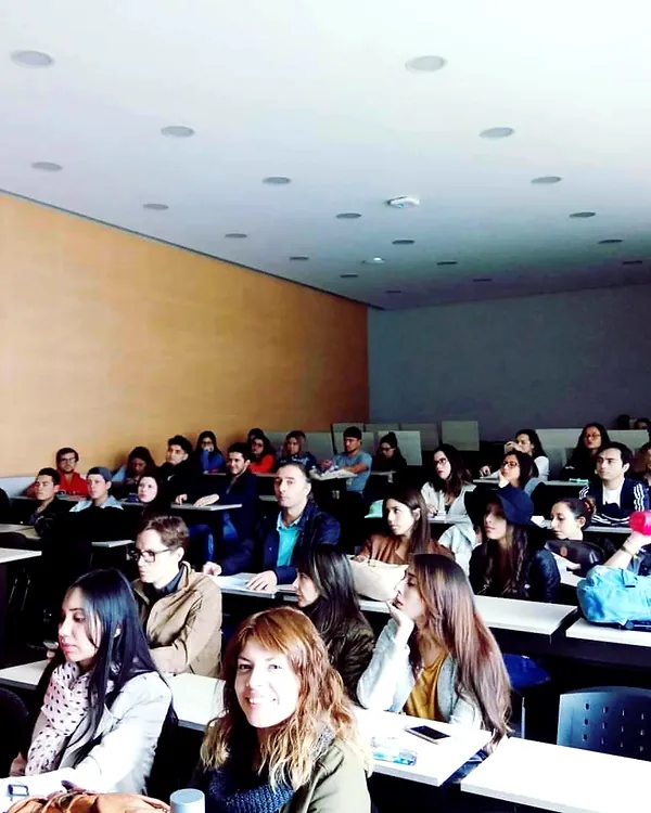Salón con estudiantes asistiendo a una conferencia de ventas
