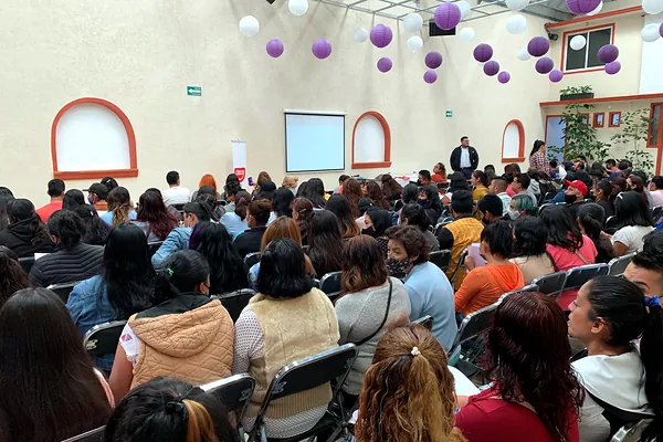 Asistentes en una conferencia de ventas en un salón decorado