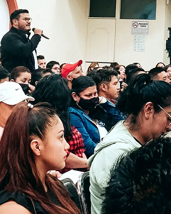 Ray Marfil hablando con micrófono frente a un grupo de estudiantes