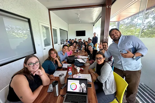 Ray Marfil guiando una sesión de trabajo con un equipo en sala de juntas