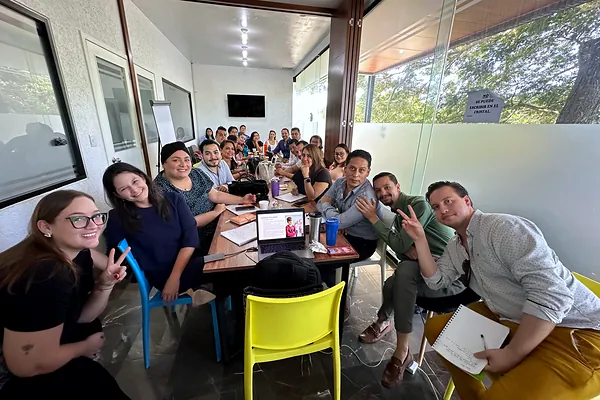 Equipo de ventas posando durante una dinámica del taller